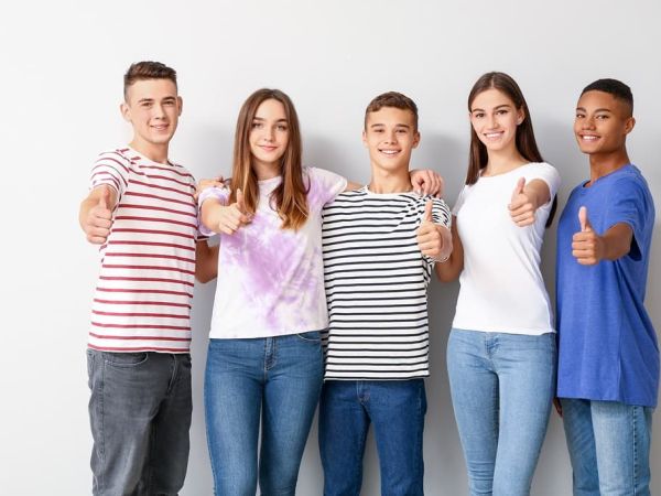 Cool teenagers showing thumb-up on white background